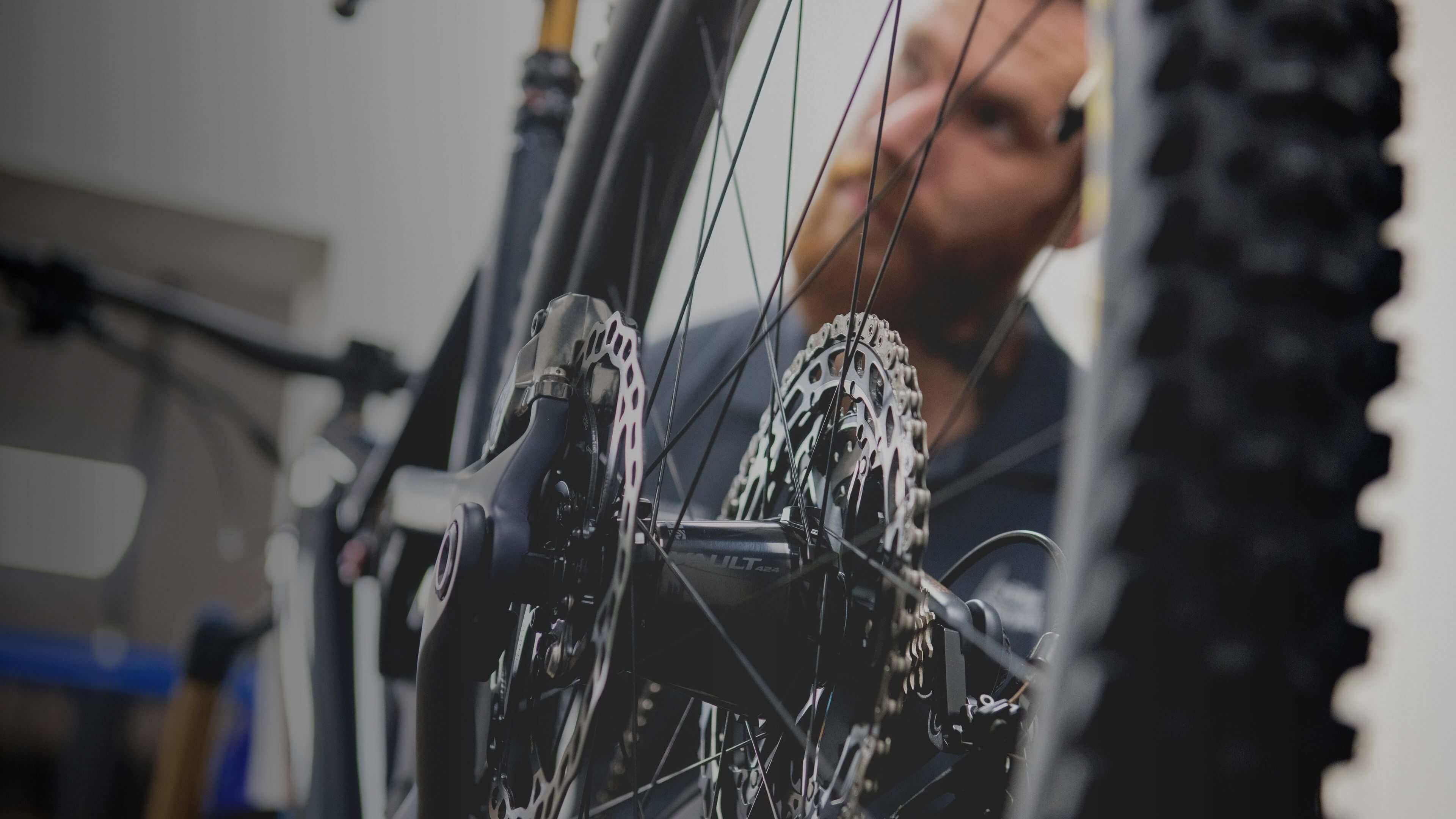 Close-up of bicycle brake components being checked and adjusted in a workshop