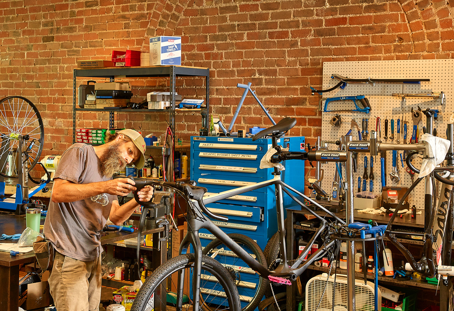 Bicycle mechanic fine-tuning a gear system and checking shifting performance