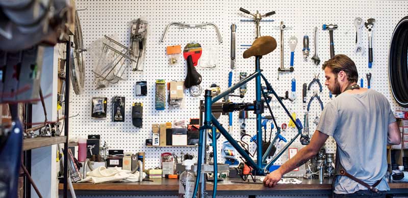 Mechanic examining a bicycle and preparing tools for a thorough service appointment